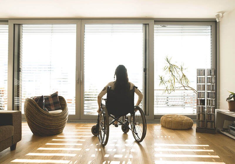 Frau in Rollstuhl im Wohnzimmer
